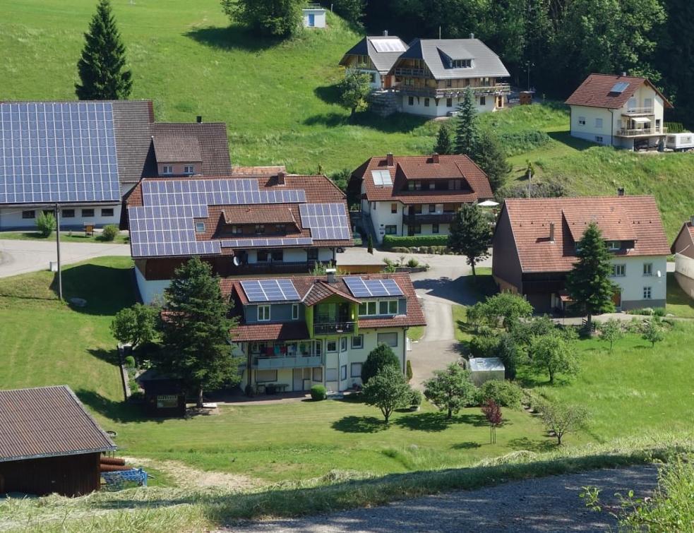 Paysage avec des maisons de village équipées de panneaux photovoltaïques