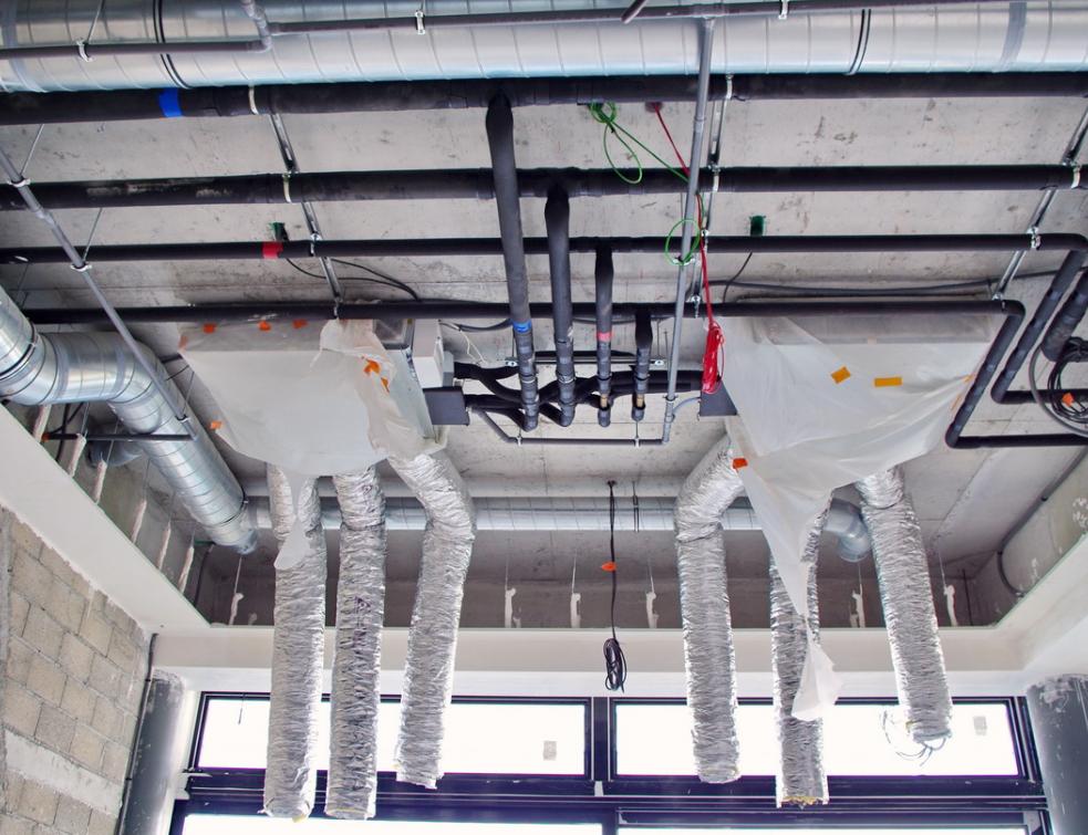 Un réseau d'eau glacée en cours d'installation au plafond d'un local tertiaire