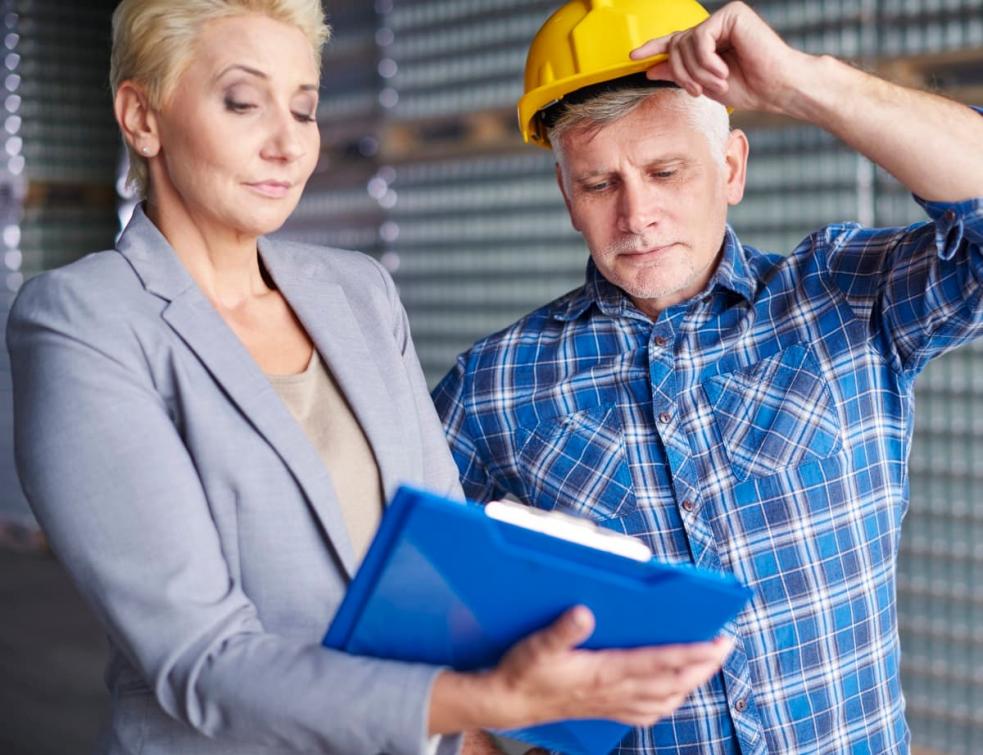 Un homme et femme regardant un contrat sur un chantier