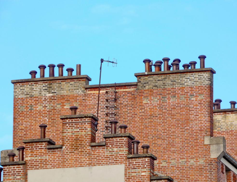 Les conduits de cheminées en briques sur des bâtiments parisiens. © PP