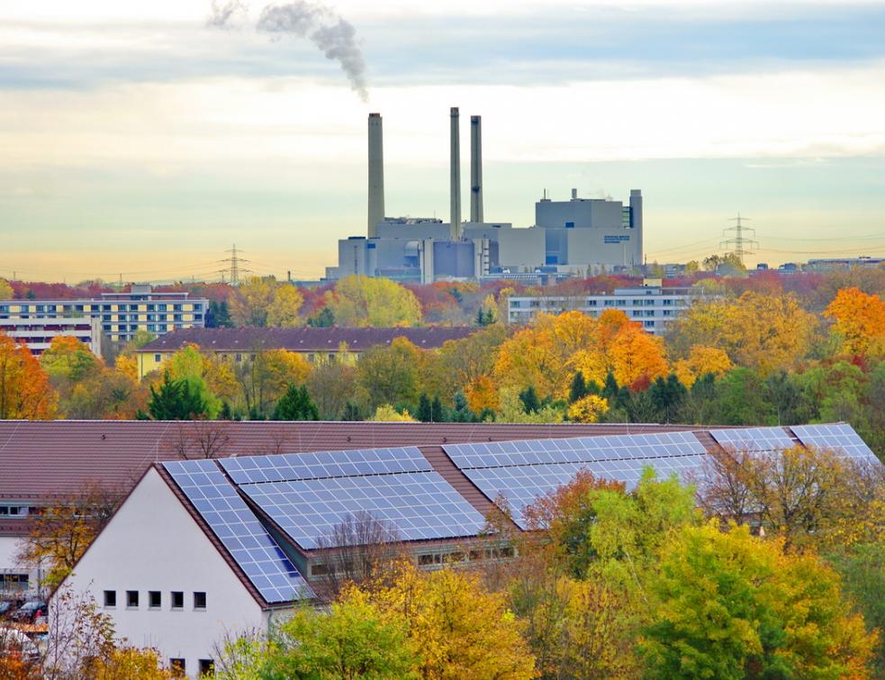 Au premier plan, production d'électricité photovoltaïque sur toitures; au fond, une centrale thermique classique au gaz. ©
