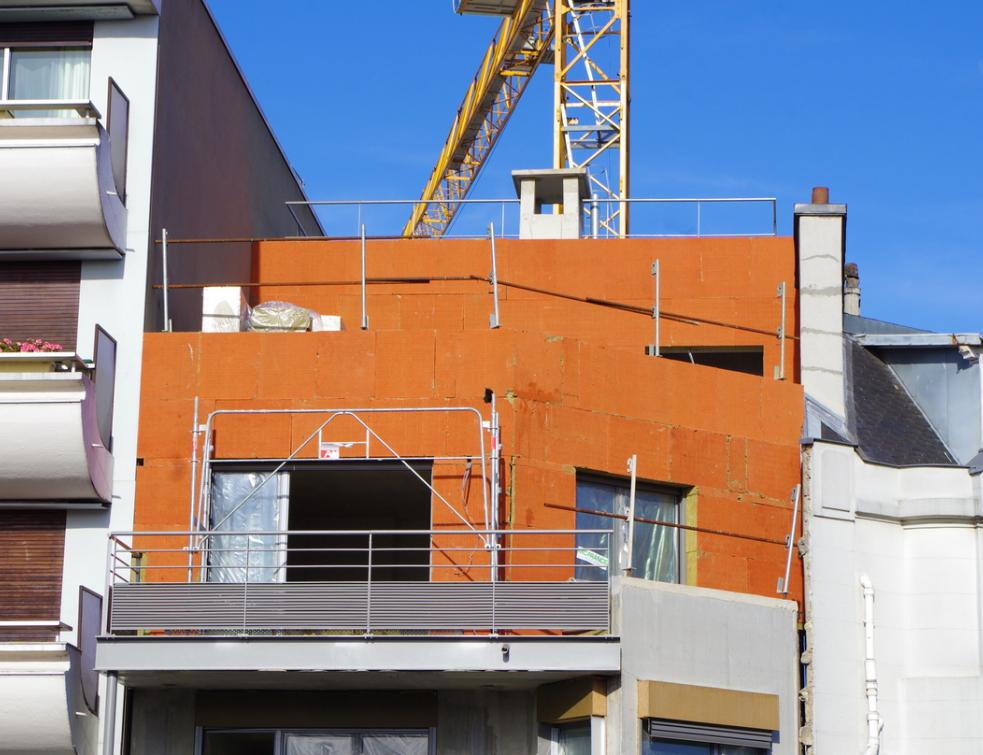Un bâtiment de loge!ments collectifs en construction avec isolation thermique par l'extérieur