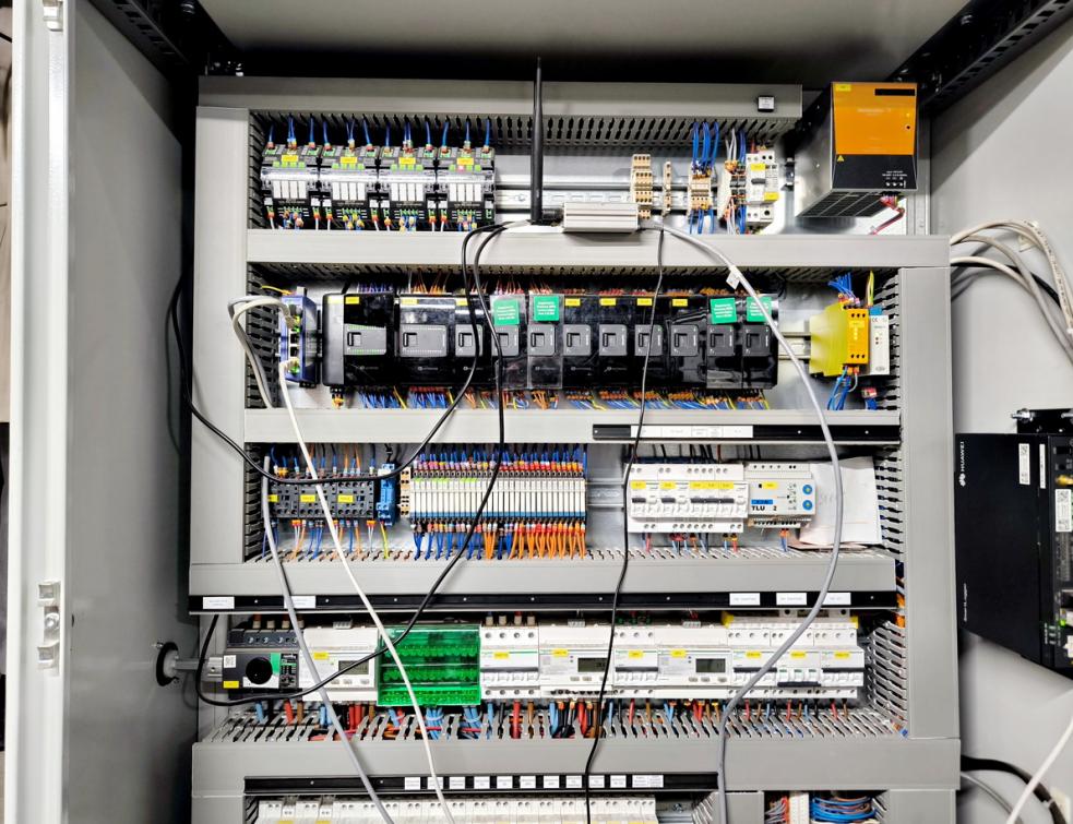 Une armoire de GTB ouverte montrant les automates de régulation montés sur rails DIN